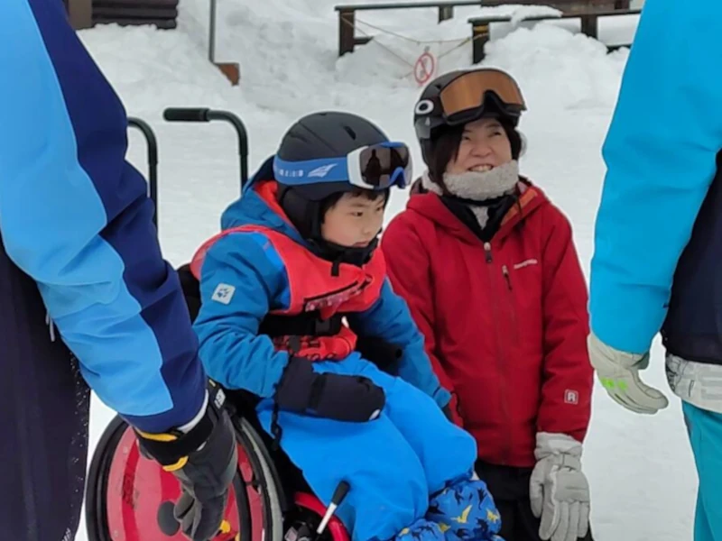 雪の上で笑顔の女性と子供